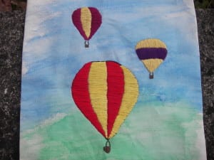 Three hot air balloons embroidered on a flag
