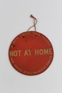 A round red sign which states 'not at home'