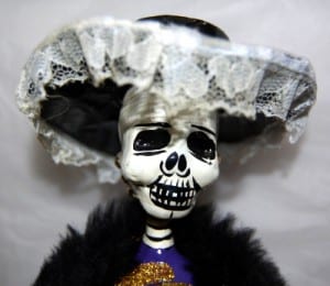 Photo of a doll with a skull face and lace hat