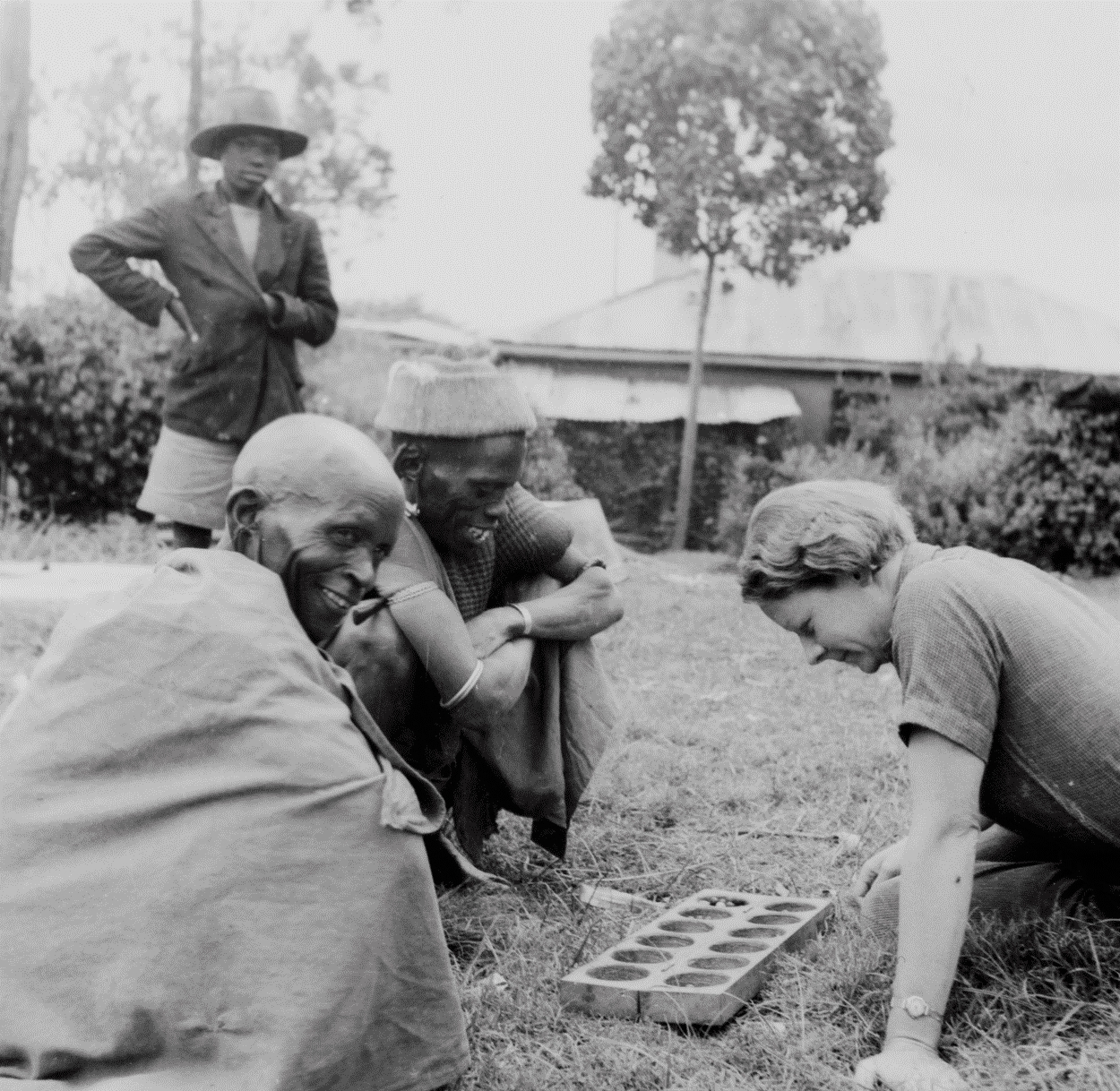 Elspeth Huxley playing mancala with two Kikuyu men, 1930s