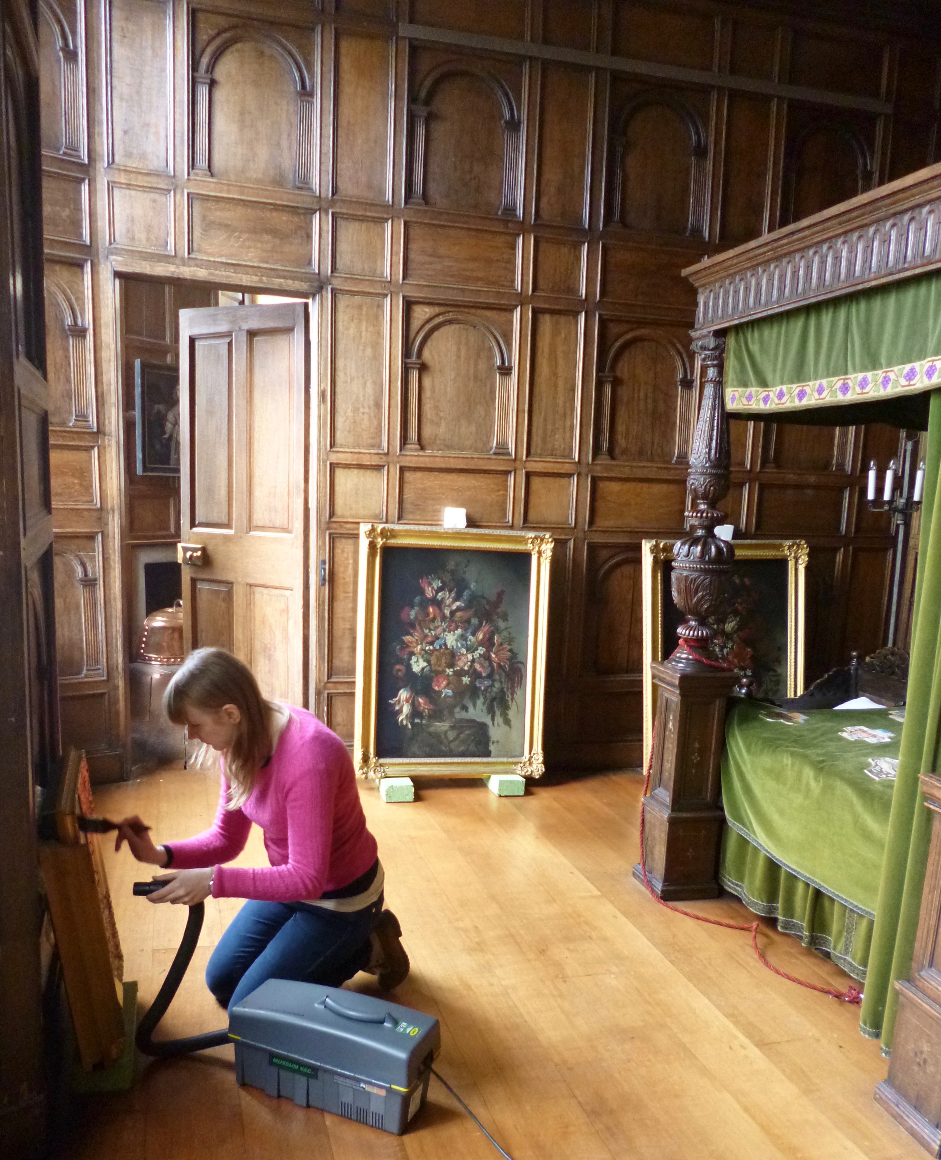 Paintings in the Red Lodge being vacuumed by a special cleaner.