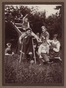 Children sat on a see-saw in the countryside