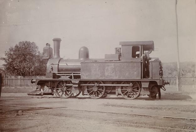 Photogrpah showing a British-manufactured steam locomotive at a siding from the Jamaica Railway 