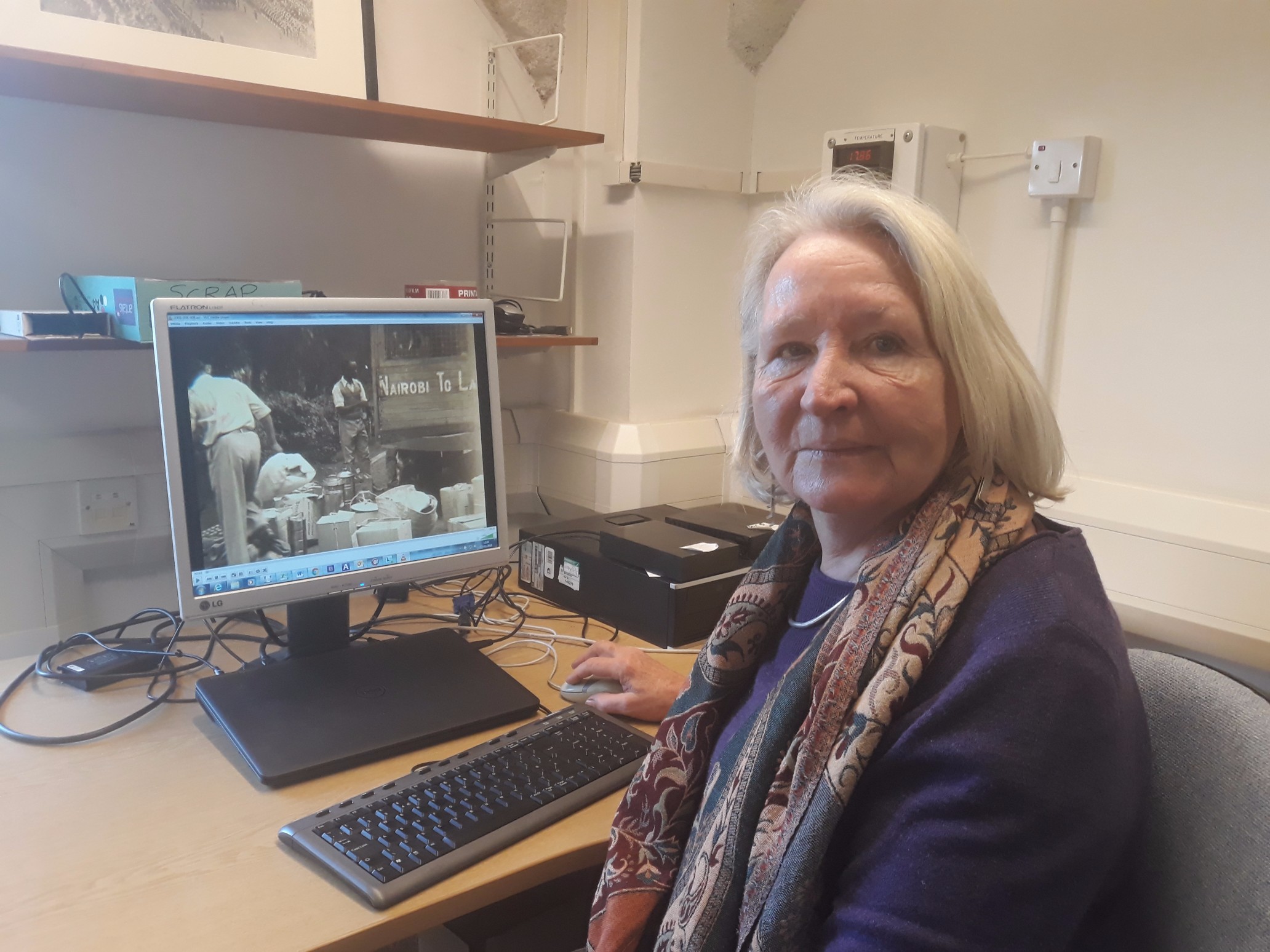 Photo of blog author Pat Ellingham sat in front of a computer cataloging the British Empire and Commonwealth collection