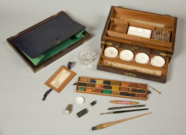An artist's watercolour box, made of wood with brass inlays, containing various tools and materials