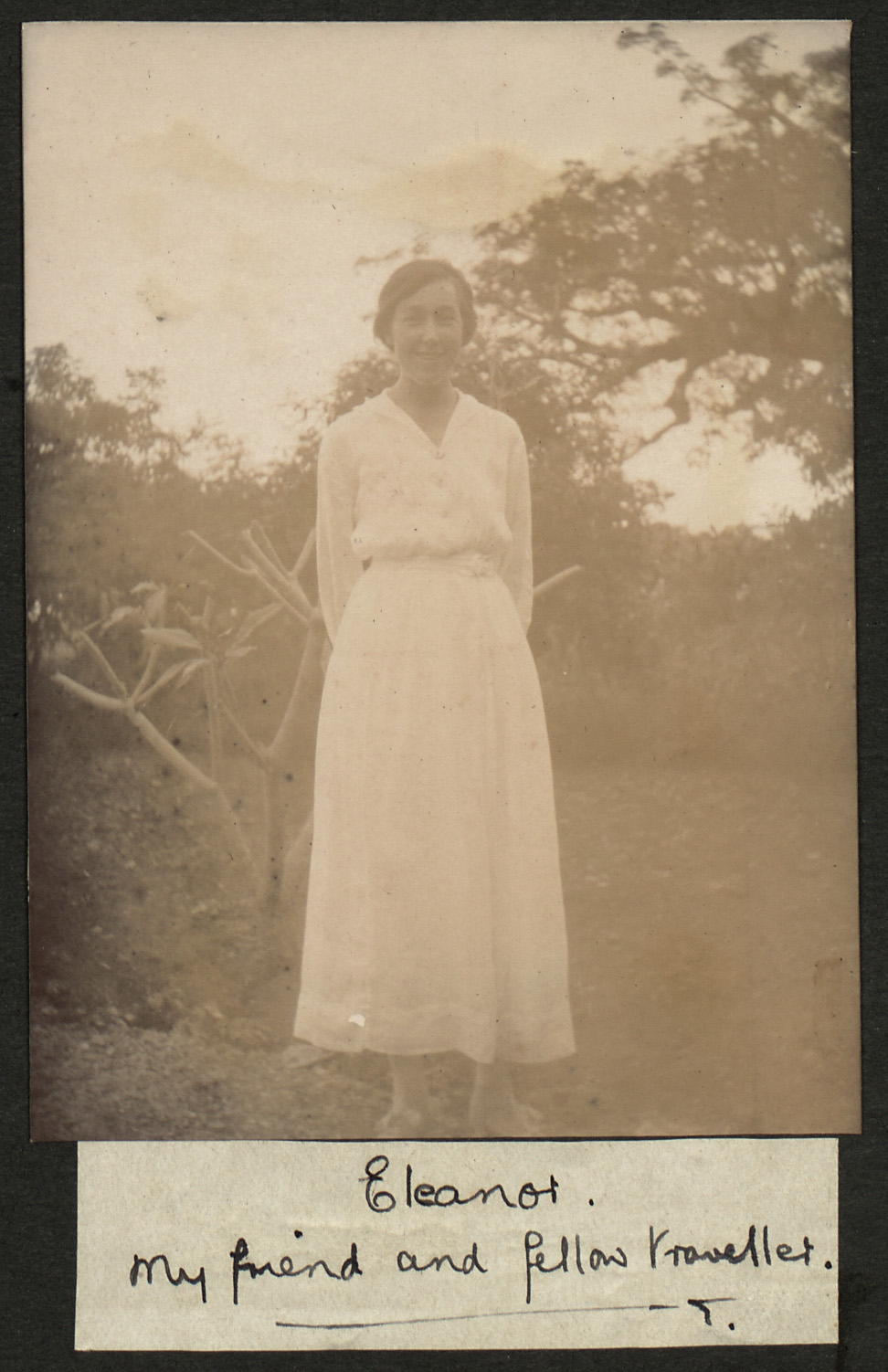 Old Photgraph of Eleanor Kemp, a woman mentioned in the diary. She is smiling, clothed in a long white dress and surrounded by trees,