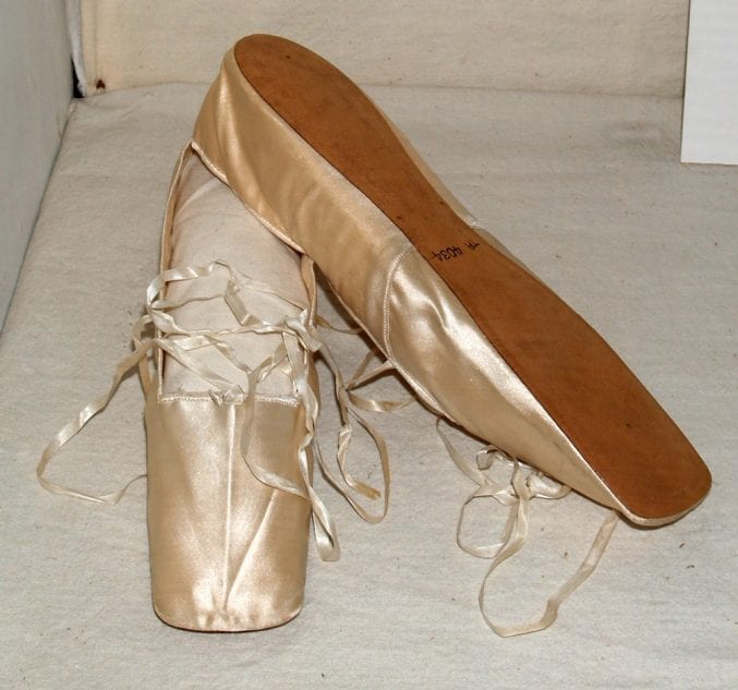 Photo of a pair of cream satin ballet shoes