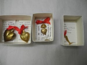 Three gold Mexican charms with red ribbon in boxes