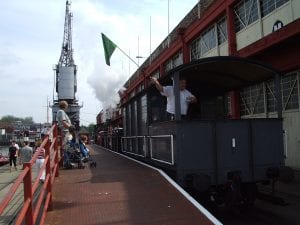 Steam train outside the M Shed. Train driver waves the flag ready to go.
