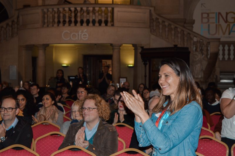 Photograph of audience applauding at uncomfortable truths launch, along with Claire Simmons, Youth Engagement officer at Bristol museum and Art gallery
