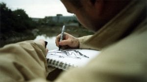 A street artist sketching with a black sharpie