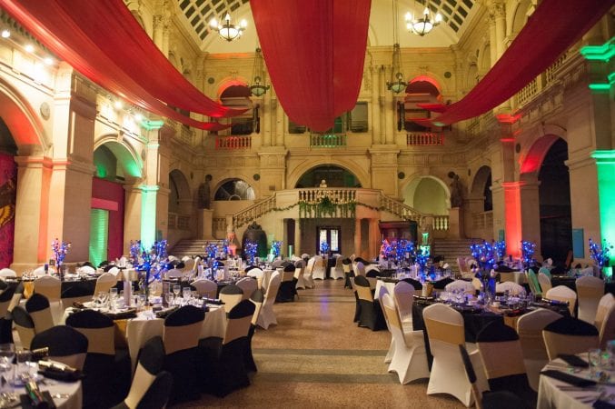 Tables laid for dinner at Bristol Museum & Art Gallery and red drapes hanging from the ceiling