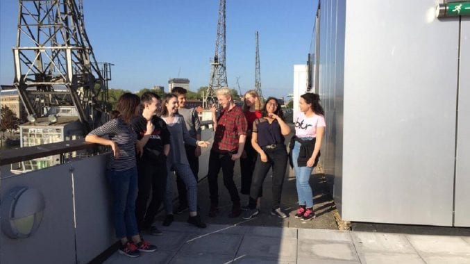 A group of seven young people stood on M Shed's terrace with Claire Simmons - the engagement officer for young people