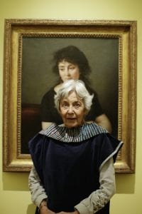 A portrait taken from a Dementia friendly creative cafe - an elderly woman sat in from of a painting in the enlightenment gallery
