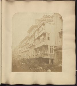 Street view of the Bristol hotel with horse and carriages and pedestrians in the foreground.