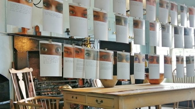 Arising: A washing line with a series of handwritten notes attached accompanied by photographs of women's eyes