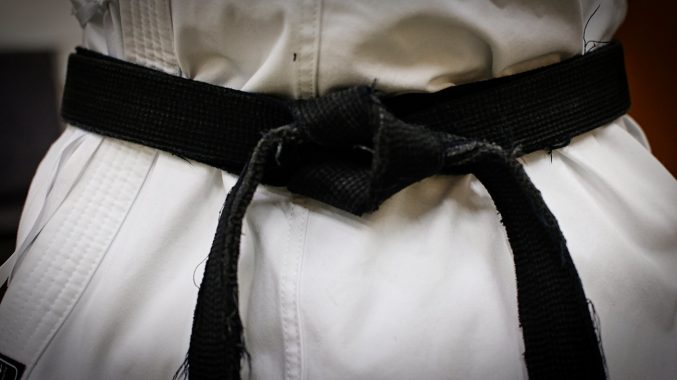 A close up of a black belt tied around the waist of a person doing martial arts © Camera Eye Photography