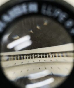 Close up view through a magnifying lens of an archive document.