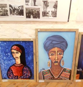 Two paintings of women leaning against a wall inside the Palestine Museum, Bristol