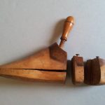This is a shoe last which was used by O'Brien,, either to get his shoes made to his size or to stretch it and prevent it from shrinking. It is a foot-shaped wooden carving, with a handle at the top and a separate piece at the back. The front part of the carving hinges open.