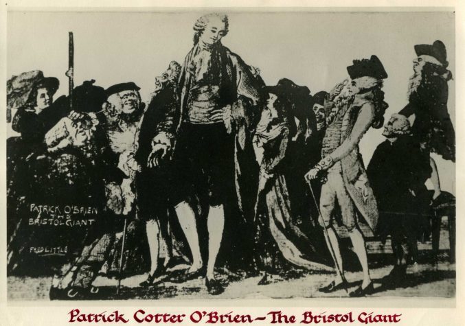 This is a postcard of O'Brien, probably from an ink drawing. It places him in the centre of the picture, among lots of much shorter people. Many lean towards him, and some look curious, others aggressive. Most of the men wear wigs, and the women wear big hats. O'Brien looks peaceful despite this, and wears a short pale wig, a frilly neckscarf or cravat, a waistcoat, breeches, long socks and shoes. 
