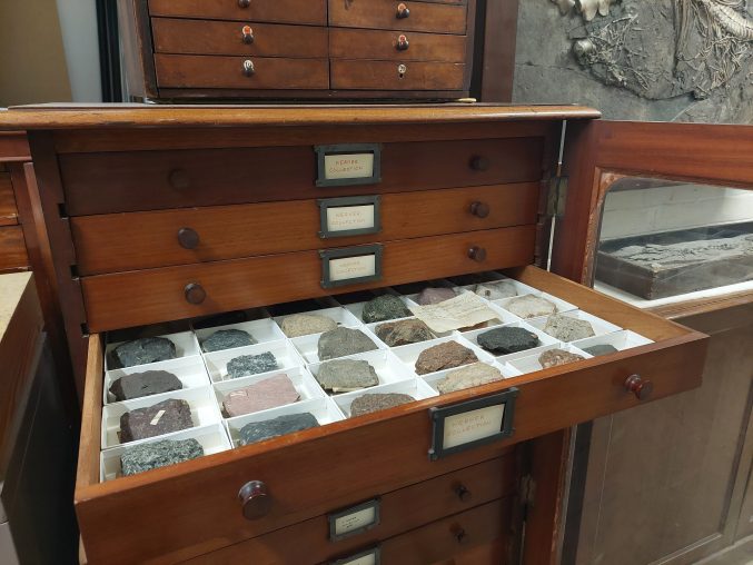museum cabinet with a drawer open showing rocks