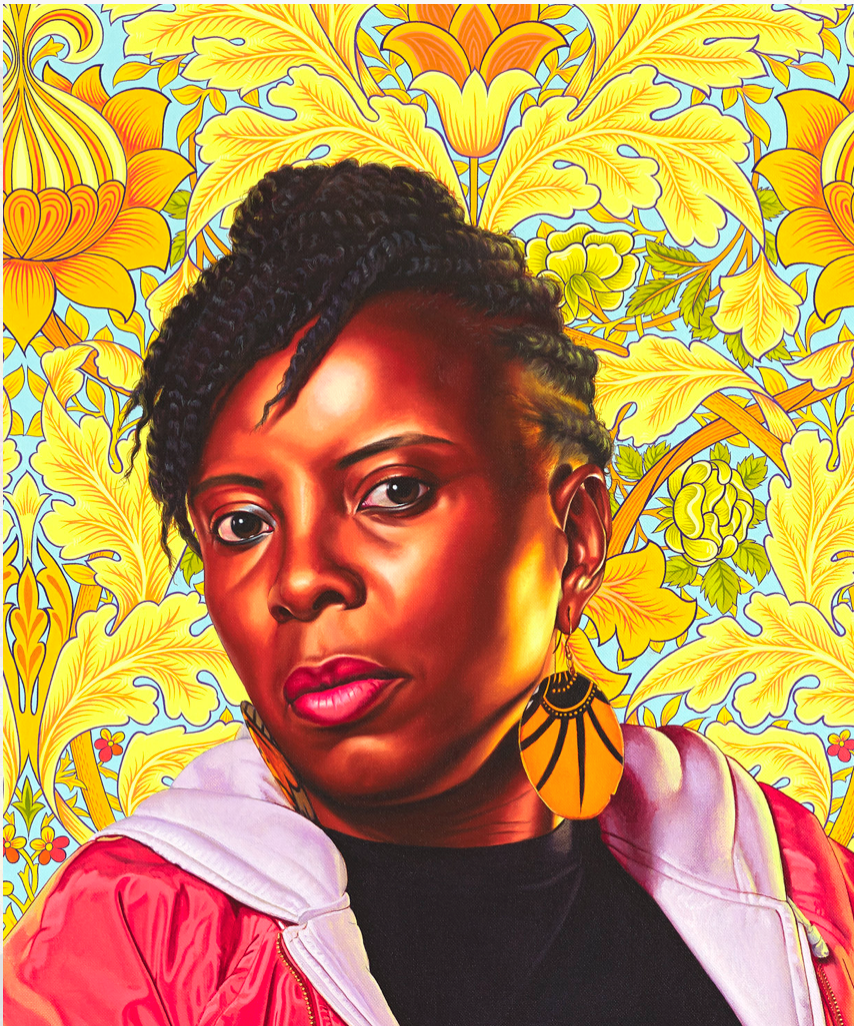Portrait of a black woman facing with head turned to left. She wears a pink hooded top and a large yellow round earing is visible. The background is a yellow floral wallpaper