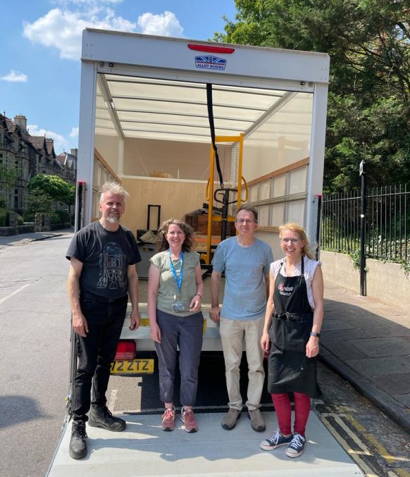 Four members of the Bristol Museum team stood at the back on a lorry.