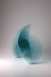 abstract blue glass sculpture depicting a wave