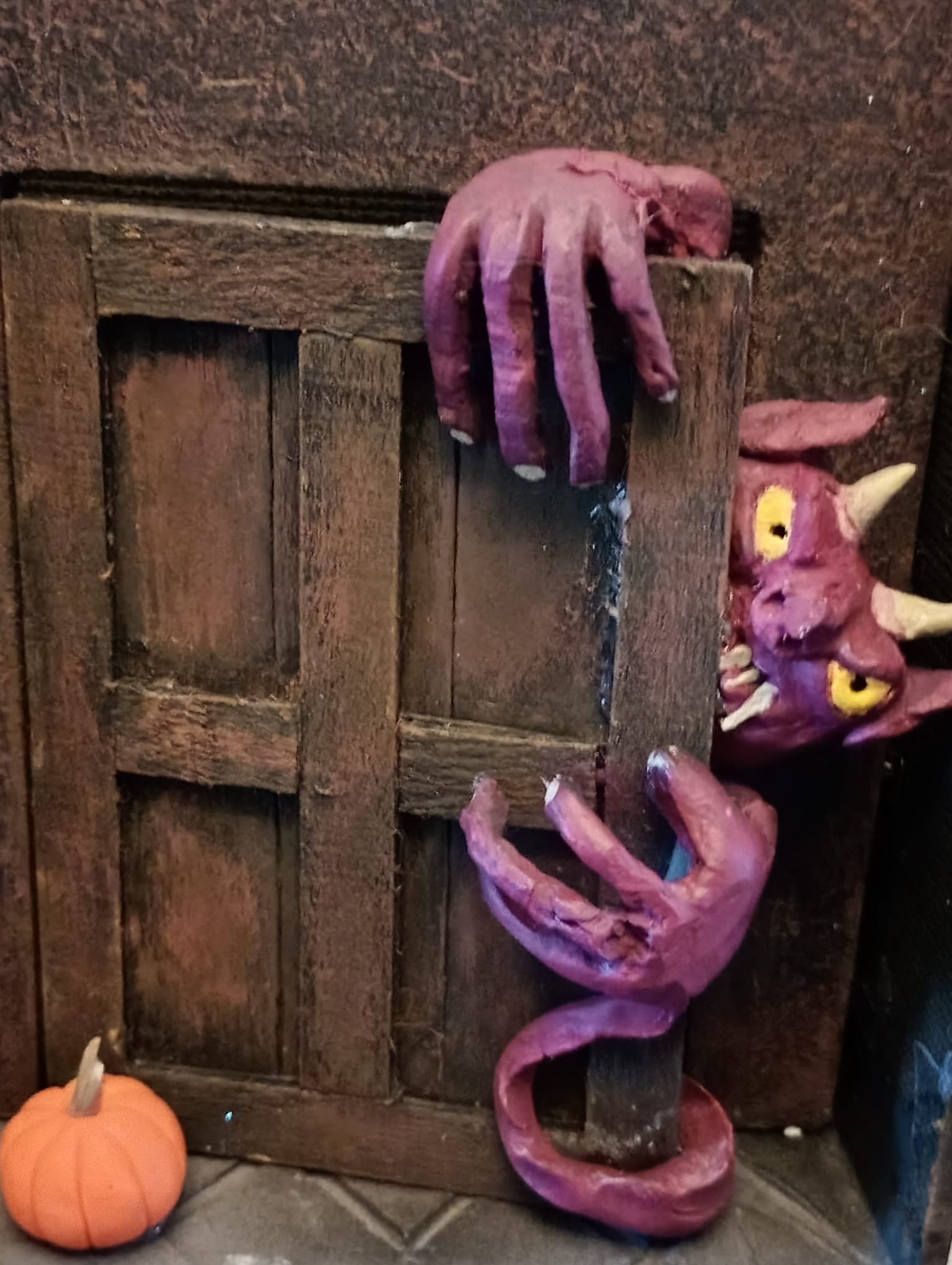 a model of a purple monster behind an oak door