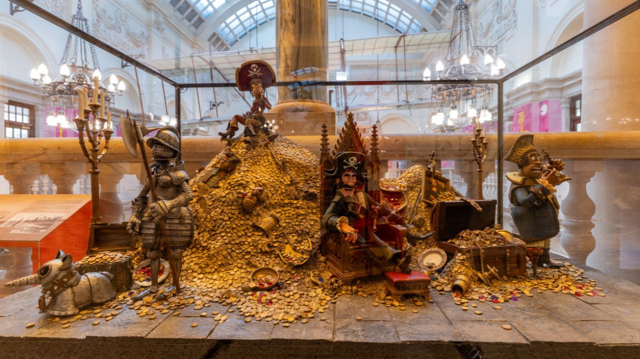 Clay models of pirates sitting on a large pile of gold coins.