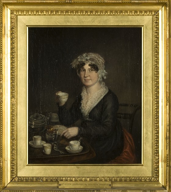 A portrait of an older woman in a black smock dress with white trim and white cap