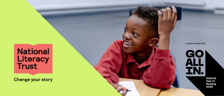 a young child smiles as he reads a book. words: National Literacy Trust. Go All In