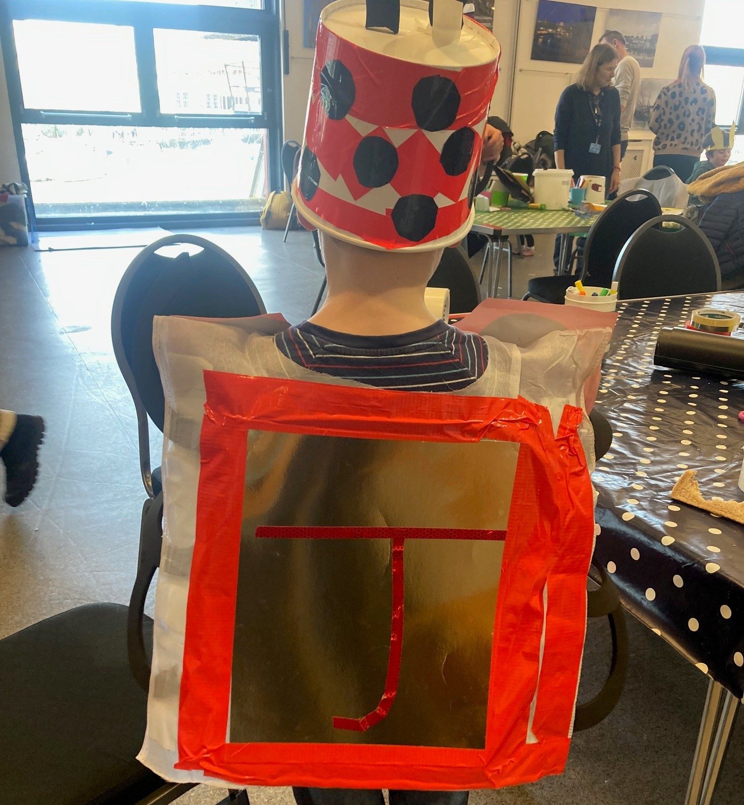the back of a child in a red hat and World book day costume