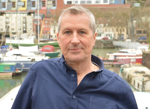 A white man with short grey hair wearing a navy blue shirt