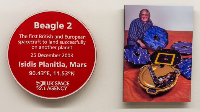 a red plaque next to a photograph displayed on a wall